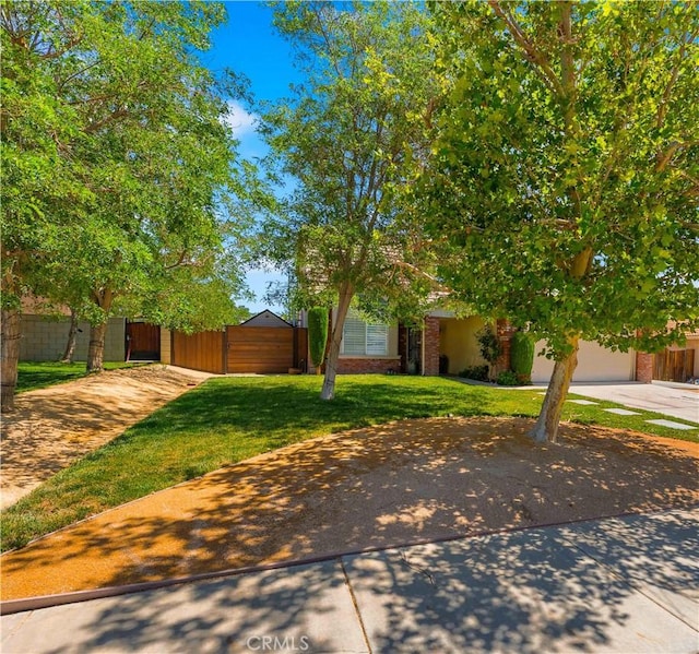 37398 Harrow Ct, Palmdale, CA 93550 - view of green lawn with concrete driveway and an attached garage