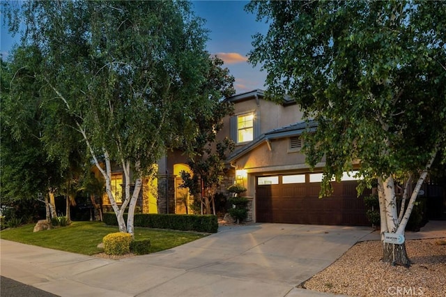 24274 Reyes Adobe Way, Valencia, CA 91354 - obstructed view of property with concrete driveway, stucco siding, a front yard, and an attached garage