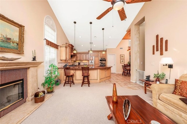5618 Gardendale Ln, Palmdale, CA 93551 - living room with high vaulted ceiling, ceiling fan, light carpet, and a tile fireplace