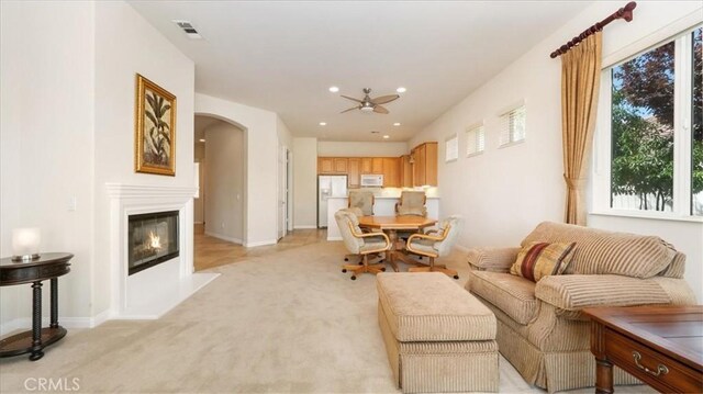 19484 Vermillion Ln, Apple Valley, CA 92308 - living room featuring arched walkways, a ceiling fan, light carpet, a glass covered fireplace, and recessed lighting