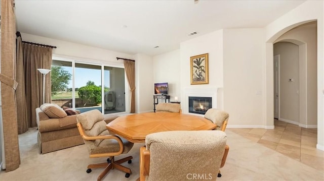 19484 Vermillion Ln, Apple Valley, CA 92308 - dining room featuring a glass covered fireplace, arched walkways, and baseboards