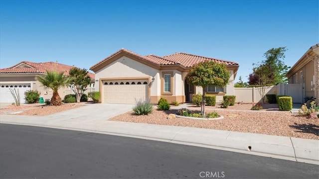19484 Vermillion Ln, Apple Valley, CA 92308 - mediterranean / spanish-style house featuring an attached garage, stucco siding, a tiled roof, and driveway
