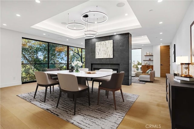 14899 Round Vly, Sherman Oaks, CA 91403 - dining room with a tray ceiling, light wood finished floors, recessed lighting, a fireplace, and baseboards