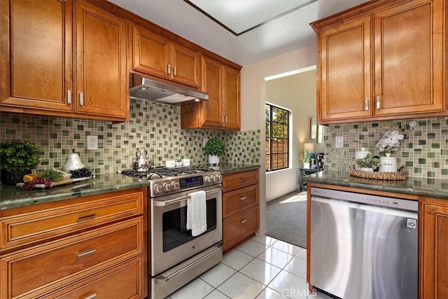 650 Bull Frog Cir, Walnut, CA 91789 - kitchen featuring appliances with stainless steel finishes, under cabinet range hood, brown cabinetry, light tile patterned floors, and backsplash
