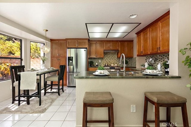 650 Bull Frog Cir, Walnut, CA 91789 - kitchen featuring stainless steel refrigerator with ice dispenser, brown cabinets, a peninsula, decorative backsplash, and light tile patterned floors