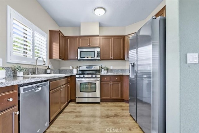 579 Camino Mercado Unit 504, Arroyo Grande, CA 93420 - kitchen with appliances with stainless steel finishes, a sink, light wood-style floors, light countertops, and brown cabinets