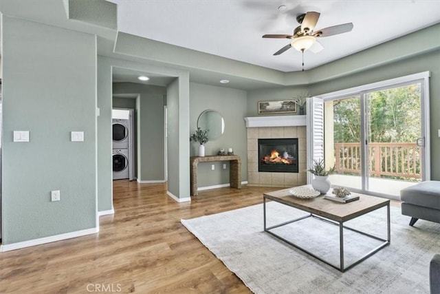 579 Camino Mercado Unit 504, Arroyo Grande, CA 93420 - living room with stacked washer / drying machine, baseboards, a fireplace, ceiling fan, and wood finished floors