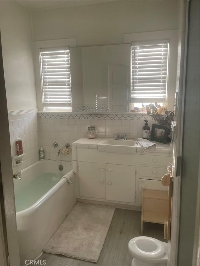 11958 Sarah St, Valley Village, CA 91607 - full bath featuring a garden tub, vanity, healthy amount of natural light, wood finished floors, and tile walls
