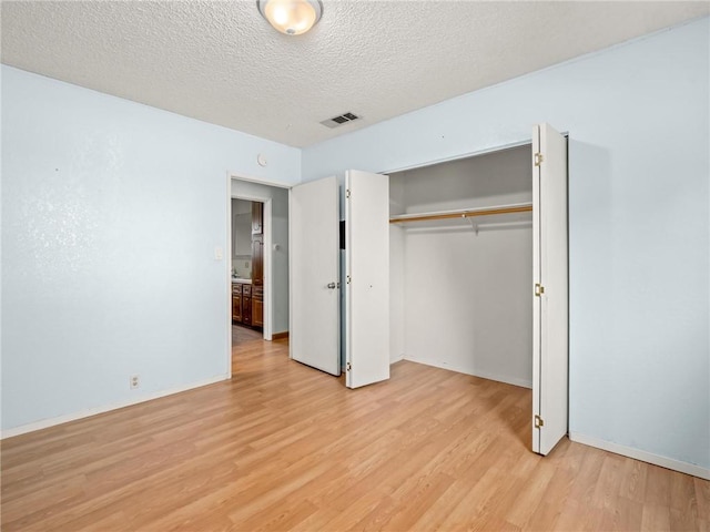 1654 W S Ave, Fresno, CA 93706 - unfurnished bedroom with light wood-style flooring, a textured ceiling, a closet, and baseboards