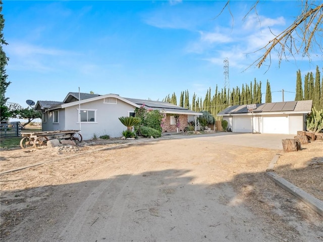 1654 W S Ave, Fresno, CA 93706 - ranch-style home with roof mounted solar panels, stucco siding, concrete driveway, and a detached garage