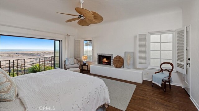 1305 E Balboa Blvd, Newport Beach, CA 92661 - bedroom featuring dark wood-style floors, a lit fireplace, baseboards, and a ceiling fan