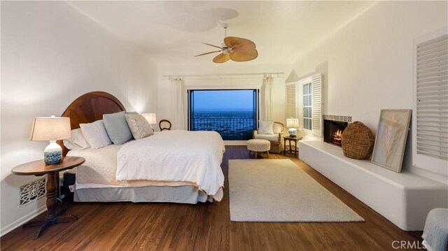 1305 E Balboa Blvd, Newport Beach, CA 92661 - bedroom with a lit fireplace, wood finished floors, and ceiling fan