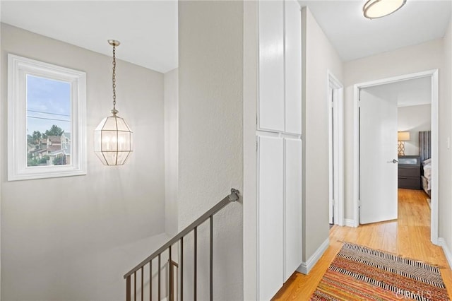 20028 Strathern St, Winnetka, CA 91306 - corridor featuring an upstairs landing, light wood-type flooring, baseboards, and a chandelier