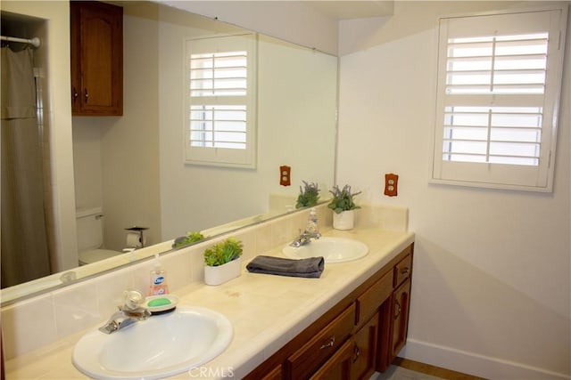 1301 Charterten Ave, Bakersfield, CA 93307 - bathroom with double vanity, plenty of natural light, toilet, and a shower