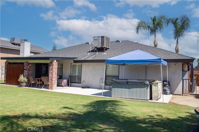 1301 Charterten Ave, Bakersfield, CA 93307 - back of property with a hot tub, central air condition unit, a patio, a shingled roof, and stucco siding