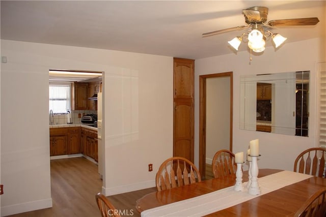 1301 Charterten Ave, Bakersfield, CA 93307 - dining space with ceiling fan, light wood finished floors, and baseboards