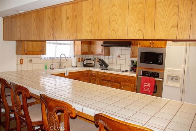 1301 Charterten Ave, Bakersfield, CA 93307 - kitchen with oven, built in microwave, under cabinet range hood, and backsplash