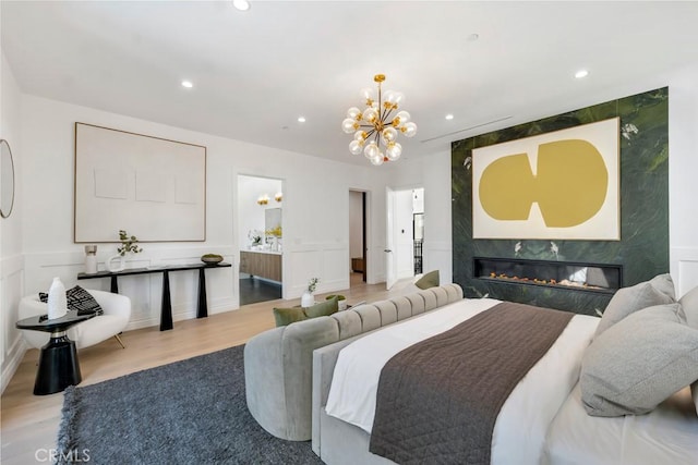 11835 Kling St, Valley Village, CA 91607 - bedroom featuring a chandelier, wood finished floors, recessed lighting, a premium fireplace, and ensuite bath