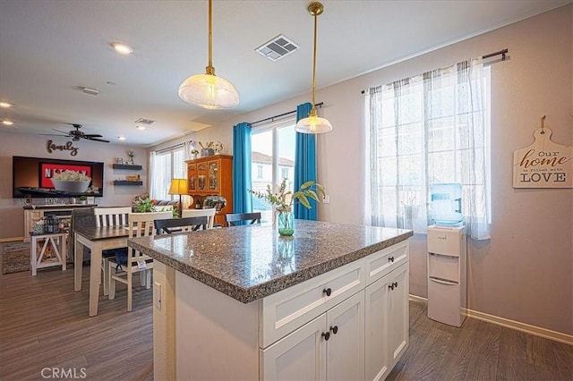 5240 Wintercress Ave, Fontana, CA 92336 - kitchen featuring dark wood-style floors, white cabinetry, pendant lighting, a center island, and ceiling fan