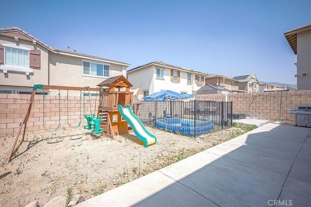 5240 Wintercress Ave, Fontana, CA 92336 - view of play area featuring a fenced backyard, a residential view, and a patio area