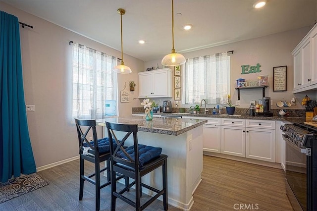 5240 Wintercress Ave, Fontana, CA 92336 - kitchen featuring range, plenty of natural light, dark wood finished floors, white cabinets, and recessed lighting