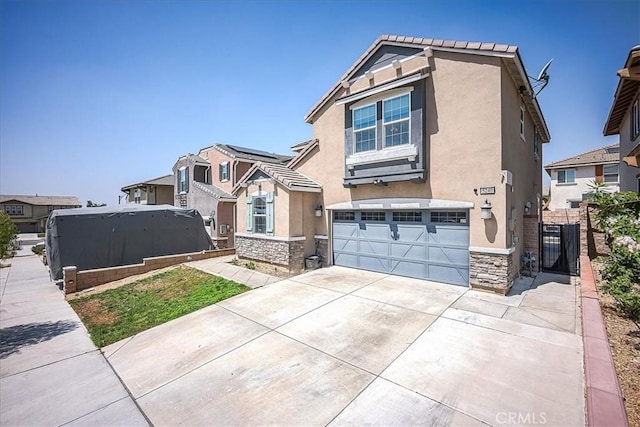 5240 Wintercress Ave, Fontana, CA 92336 - view of front of home with stucco siding, stone siding, an attached garage, and driveway