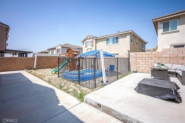 5240 Wintercress Ave, Fontana, CA 92336 - fenced backyard with a patio, a playground, an outdoor living space, and a residential view