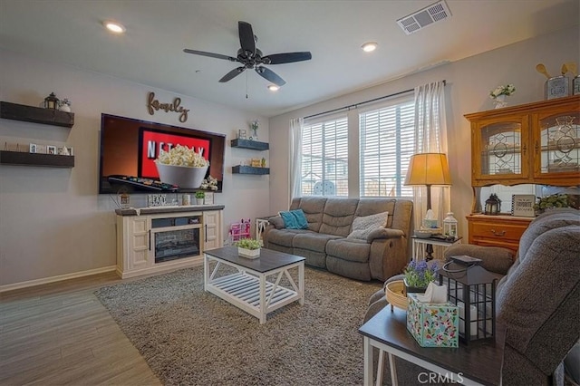5240 Wintercress Ave, Fontana, CA 92336 - living area with wood finished floors, a ceiling fan, recessed lighting, and a glass covered fireplace