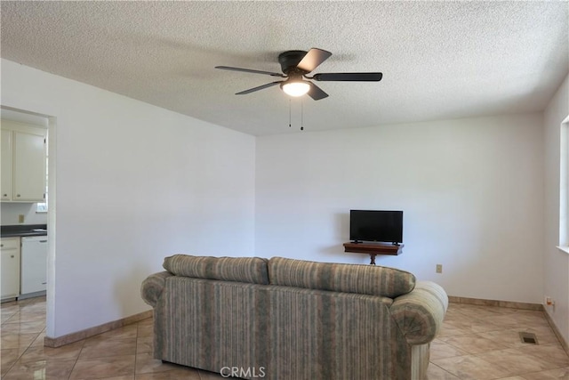 512 Maple St, Willows, CA 95988 - living room featuring a ceiling fan, baseboards, light tile patterned floors, and a textured ceiling