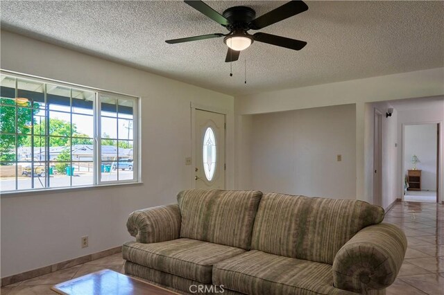 512 Maple St, Willows, CA 95988 - tiled living room featuring a textured ceiling, a ceiling fan, and baseboards