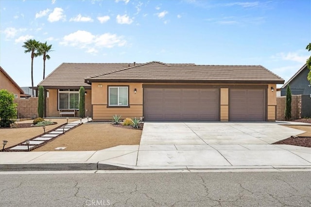 1331 Nicholas Ct, Rialto, CA 92377 - view of front of home with a garage, concrete driveway, a tiled roof, and stucco siding