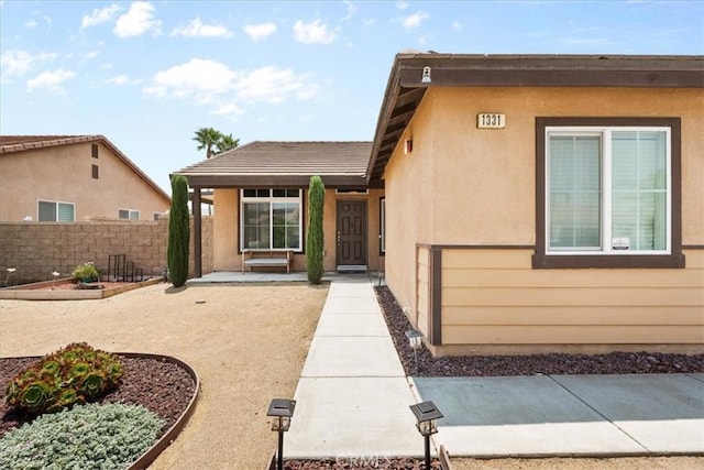 1331 Nicholas Ct, Rialto, CA 92377 - view of exterior entry featuring stucco siding, a patio area, and a tile roof