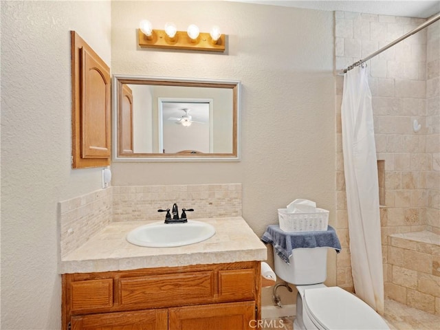13044 Smith Rd, Phelan, CA 92371 - bathroom with vanity, toilet, a tile shower, a ceiling fan, and a textured wall