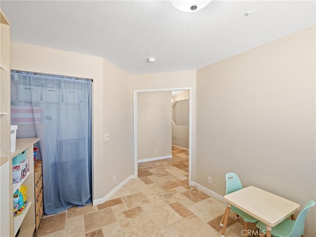 13044 Smith Rd, Phelan, CA 92371 - playroom featuring light stone finish flooring, baseboards, and a textured ceiling