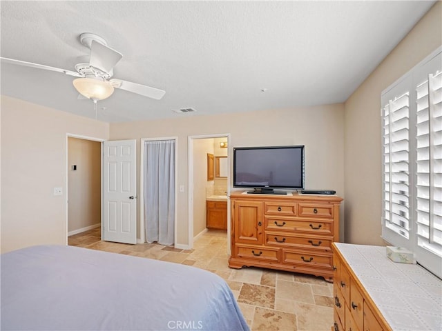 13044 Smith Rd, Phelan, CA 92371 - bedroom with connected bathroom, a ceiling fan, and light stone finish floors