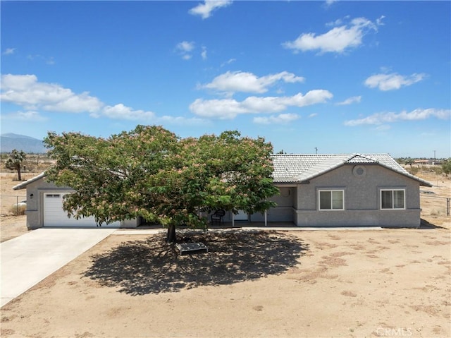 13044 Smith Rd, Phelan, CA 92371 - view of front of house featuring driveway, a tiled roof, stucco siding, an attached garage, and a mountain view
