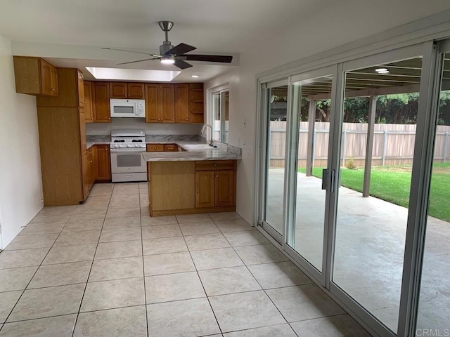 3465 Spanish Way, Carlsbad, CA 92008 - kitchen with white appliances, a ceiling fan, brown cabinets, light tile patterned floors, and a sink