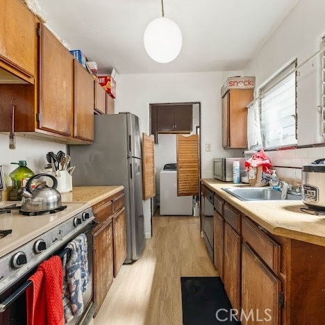 919 Dexter St, Los Angeles, CA 90042 - kitchen with stainless steel electric range, washer / clothes dryer, light wood-type flooring, and light countertops