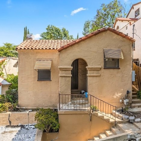 919 Dexter St, Los Angeles, CA 90042 - mediterranean / spanish-style house featuring a tiled roof, stucco siding, and stairway