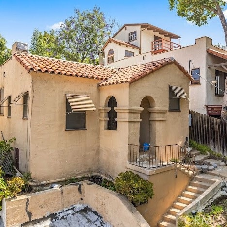919 Dexter St, Los Angeles, CA 90042 - mediterranean / spanish home featuring a tile roof, stucco siding, and stairway