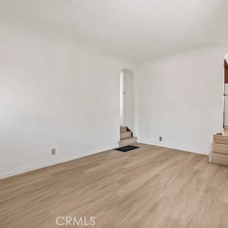 919 Dexter St, Los Angeles, CA 90042 - unfurnished living room with stairway, arched walkways, and light wood finished floors