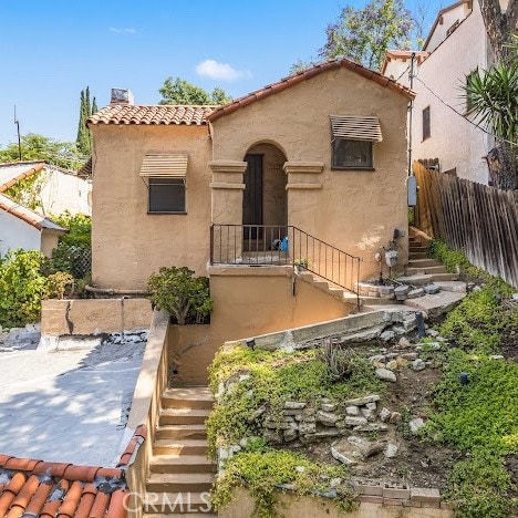 919 Dexter St, Los Angeles, CA 90042 - view of front facade featuring stairs, a tiled roof, stucco siding, and a chimney