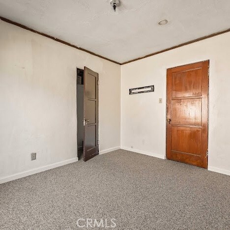 919 Dexter St, Los Angeles, CA 90042 - spare room featuring ornamental molding and carpet