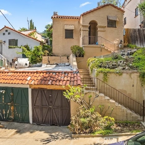 919 Dexter St, Los Angeles, CA 90042 - rear view of property featuring a tiled roof, stucco siding, and stairway