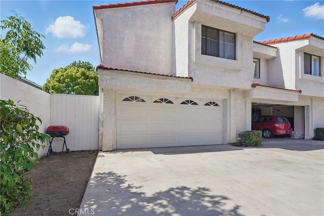 140 W 220th St Unit 105, Carson, CA 90745 - mediterranean / spanish home with a garage, a tile roof, stucco siding, and concrete driveway