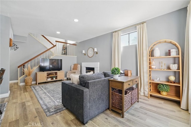 140 W 220th St Unit 105, Carson, CA 90745 - living area with stairs, light wood-style flooring, a brick fireplace, recessed lighting, and baseboards