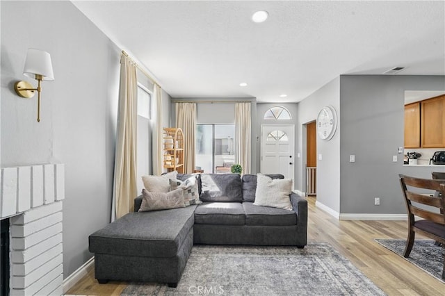 140 W 220th St Unit 105, Carson, CA 90745 - living room featuring light wood finished floors, baseboards, a brick fireplace, and recessed lighting
