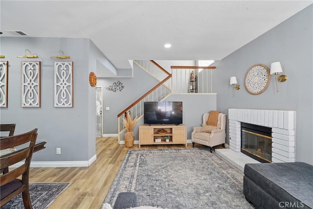 140 W 220th St Unit 105, Carson, CA 90745 - living area with wood finished floors, stairs, baseboards, a brick fireplace, and recessed lighting