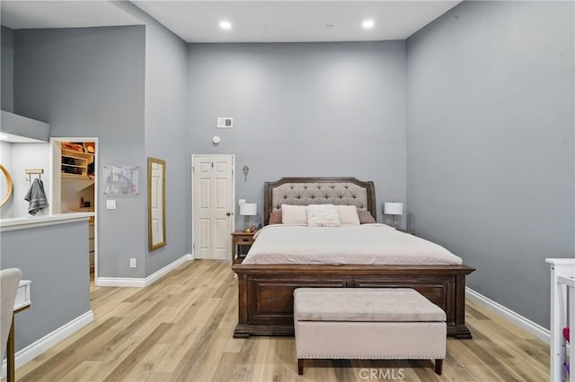 140 W 220th St Unit 105, Carson, CA 90745 - bedroom with light wood-style flooring, a high ceiling, baseboards, and recessed lighting