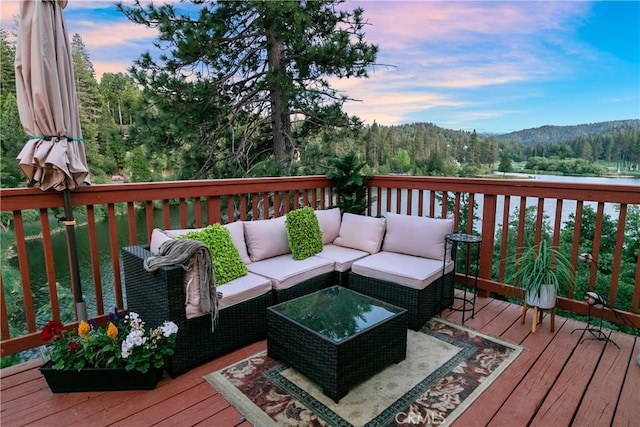 781 Brentwood Dr, Lake Arrowhead, CA 92352 - deck at dusk featuring an outdoor living space, a mountain view, and a wooded view